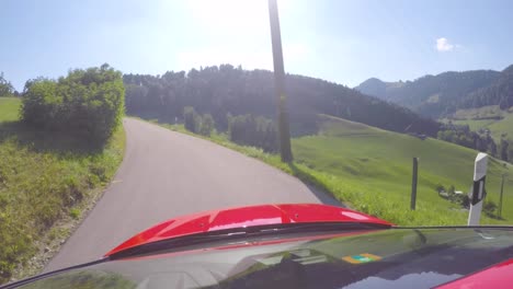 Red-Ford-Focus-drives-on-a-tiny-road-through-the-swiss-alps