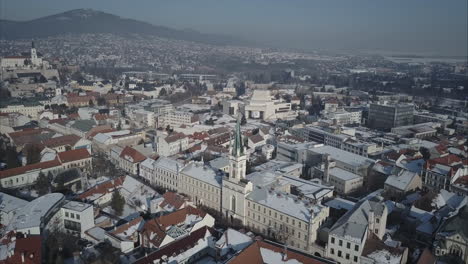 Wide-aerial-shot-of-Nitra-town-with-Castle-and-mountains-in-background,-Winter,-Slovakia