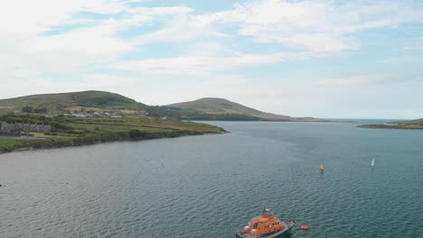 Aerial-fly-over-of-Lifeboat-at-anchor-with-2-small-sailing-dinghies-approaching,Location-Iveragh-Peninsula,-Portmagee-on-left-and-Valentia-Island-on-right,-Co-Kerry