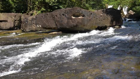 Weite-Aufnahme-Von-Wasser,-Das-Von-Einem-Kleinen-Wasserfall-Den-Fluss-Hinunterströmt
