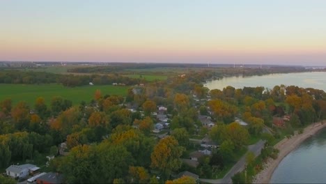 Beautiful-forward-flying-drone-shot-over-the-town-of-Selkirk-at-sunset-near-Lake-Erie-in-Ontario,-Canada
