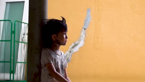 Junger-Südostasiatischer-Schmutziger-Obdachloser-Junge,-Der-In-Die-Ferne-Schaut-Und-Sich-Nach-Einem-Normalen-Leben-In-Zeitlupe-Sehnt