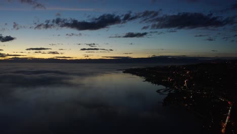 Aerial-hyperlapse-over-the-shore-of-Lake-Léman-at-dusk-with-fog-patches-low-over-the-lake