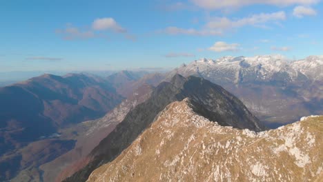 Tiefflug-über-Den-Bergrücken,-Der-Den-Gipfel-Des-Berges-Mit-Drei-Wanderern-Enthüllt