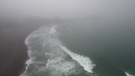 AERIAL:-A-drone-pushes-through-a-foggy-day-to-reveal-a-rocky-coastline