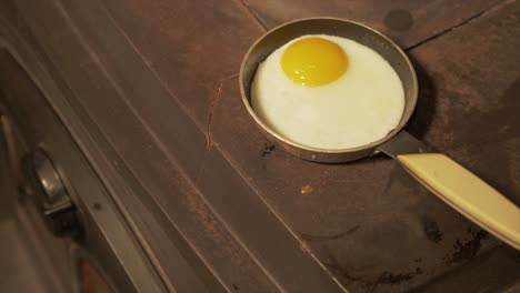 4k-frying-an-egg-on-stove-in-single-pan-zoom-in-shot