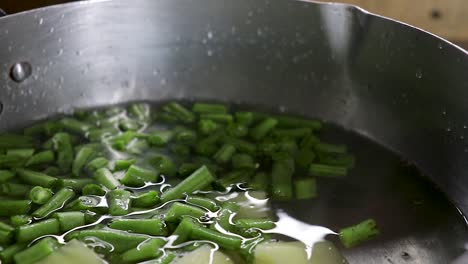 Close-up-of-Potato-and-Green-bean-pieces-put-in-pot-with-water
