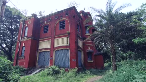 Scary-and-creepy-abandoned-old-building-exterior-with-plants-and-trees-around