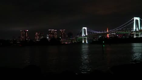 Timelapse,-The-view-of-the-Rainbow-Bridge,-Tokyo-Tower-and-reflection-on-the-sea-at-night