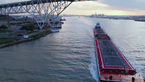working-barge-heading-out-of-port-under-the-corpus-Christi-bridge-sunset-in-the-back-drop