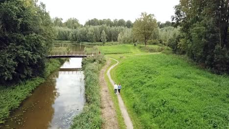 Drone-view-of-activities-in-the-park:-a-Couple-walking,-people-walking-their-dog-and-more-at-the-canal