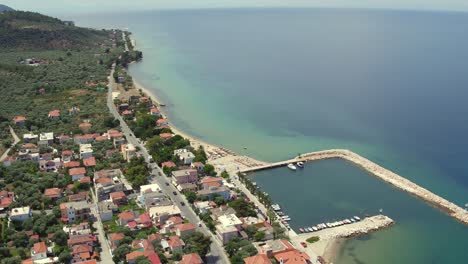 Aerial-pan-up-shot-at-Skala-Sotiros-resort-on-Thassos-island,-Greece-to-reveal-the-Agean-sea-and-mainland-Greece