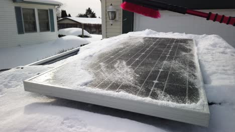 Someone-brushing-snow-off-of-a-solar-panel-that-is-mounted-on-top-of-an-SUV-at-half-speed