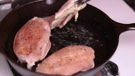 Pre-frying-three-pieces-of-filled-chicken-breasts-on-top-of-gas-stove-in-the-forged-frying-pan