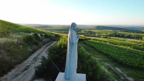 Estatua-De-María-Rezando-En-Una-Colina-Con-Hermosas-Vistas-Aéreas-Del-Paisaje