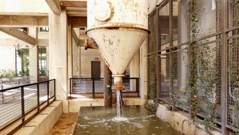 Water-gushing-out-of-old-rusty-water-tank-drained-for-maintenance