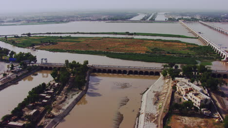 Vista-Aérea-De-Puentes-Gemelos,-Canales-Gemelos-A-Ambos-Lados-Del-Río,-Grandes-Canales-Que-Parten-Del-Río-Y-Van-Entre-La-Ciudad,-Hay-Tráfico,-Khyberpakhtunkhwa,-Pakistán