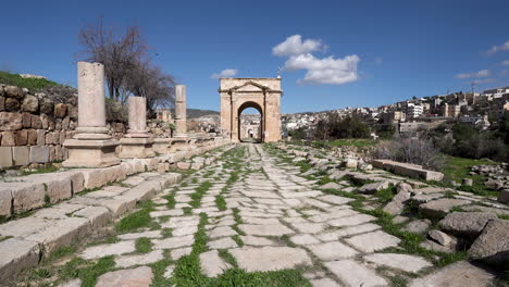 Camino-De-Piedra-Que-Conduce-A-Una-Gran-Arquitectura-Con-Hierba-Que-Crece-Entre-Los-Espacios-Del-Suelo-En-Un-Día-Soleado-En-Ruinas-Romanas-En-Jerash