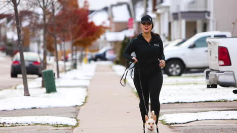 Young-woman-running-outside-with-her-dog-in-the-Winter