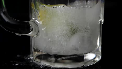 Close-up-shot-of-soda-which-flows-in-a-glas-in-slow-motion,-some-of-it-spills-out