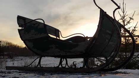Christmas-theme-with-christmas-three-and-old-santa-claus-sled-at-sunset,-Lapland,-cinematic-slider-pan-tilt