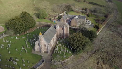 Aerial-footage-of-Arbuthnott-Church-on-a-sunny-day,-Aberdeenshire,-Scotland
