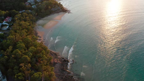 Drone-footage-of-a-quiet-small-beach-surrounded-by-forest-basking-i-nthe-afternoon-sun-near-Noosa,-Sunshine-Coast,-Australia