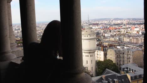 Blonde-girl-looking-at-the-Bell-Tower-of-the-Basilica-of-the-Sacred-Heart-in-Montmartre-Paris