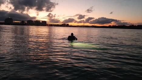 A-scuba-diver-enters-the-water-at-sunset