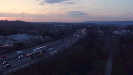 Wide-aerial-tracking-shot-of-M20-motorway-Aylesford,-Kent,-UK-shot-during-rush-hour-at-sunset