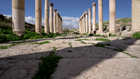 Low-Winkel-Aufnahme-Eines-Langen,-Geraden-Steinwegs-Gut-Erhaltener-Korinthischer-Säulen-In-Römischen-Ruinen-In-Jerash