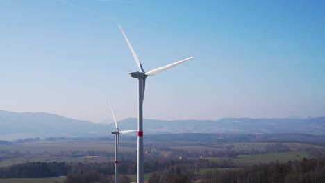 Windmills-in-fields-with-hills-in-background---panorama-shot-in-slowmo