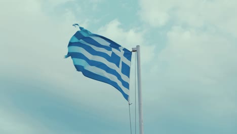 Worn-Greek-flag-blowing-in-the-wind-overcast-sky-60FPS