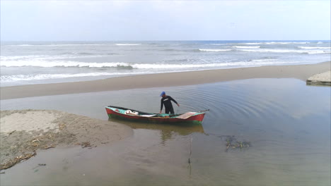 AERIAL:-Honduran-fisherman-setting-a-fish-on-his-canoe-on-the-beach