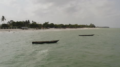 Static-shot-of-two-wooden-fishing-canoe-boats-anchored-near-the-beach-side-near-Dar-es-Salaam,-Tanzania