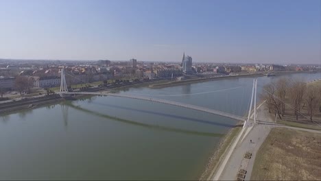 Drone-Volando-Hacia-Un-Puente-Peatonal-Colgante-En-Osijek-Croacia
