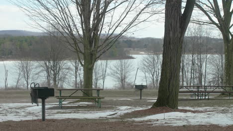 Empty-Picnic-Tables-at-Park-in-Winter-with-Lake-in-Background-PAN-RIGHT