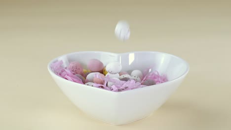 Mini-Huevos-De-Chocolate-Caídos-En-Un-Recipiente-En-Forma-De-Corazón-En-Cámara-Lenta