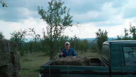 Hard-workers-load-bales-of-hay-in-pickup-truck,-medium-shot