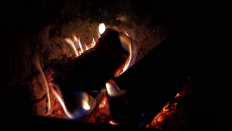 A-Handheld-Shot-of-a-Crackling-Fireplace-Burning-in-a-Dark-Place-Creating-Warmth-and-Relaxation