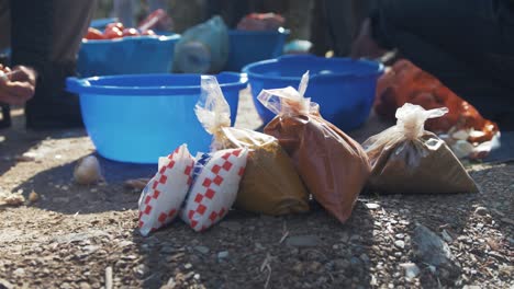 Refugiados-Preparando-Comida-Cortando-Verduras-Al-Aire-Libre-Sol-Especias-En-Primer-Plano