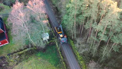 Aerial-view-of-heavy-machine-digging-a-ditch-by-forest-road