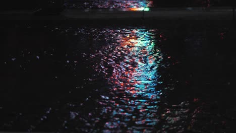 Neon-City-Street-Lights-Reflected-in-a-City-Street-Rain-Puddle