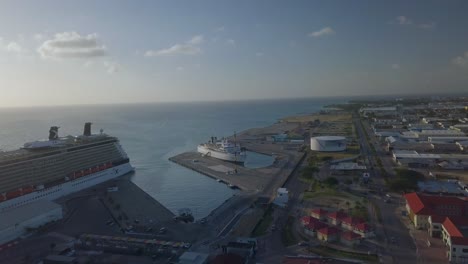 Aerial-overview-of-the-dock-next-to-the-big-cruise-ship-with-a-smaller-ship-close-by-4K