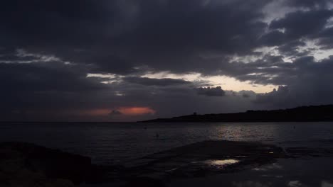Toma-En-Tiempo-Real-Del-Amanecer-En-Qawra,-Malta,-Día-Lluvioso-Nubes-Negras-Oscuras