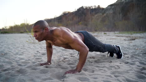 Attractive-and-athletic-man-doing-push-ups-on-a-beach