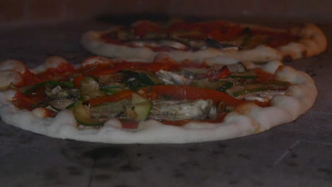 Slow-motion-of-two-pizzas-cooking-in-a-wood-fire-brick-oven