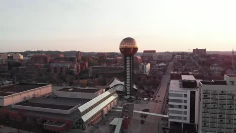 Aerial-footage-of-Sunsphere-in-downtown-Knoxville,-Tennessee-flying-straight-forwards-over-city-and-traffic