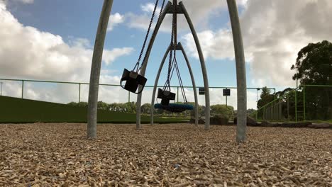 Empty-park-swings-move-to-and-fro-during-the-day-at-the-kids-playground