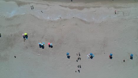 Aerial-Timelapse-of-beach-umbrellas-and-waves